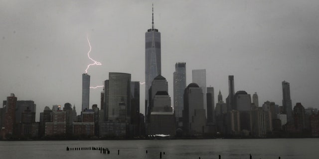 Lightning strikes behind lower Manhattan and One World Trade Center during a thunderstorm in New York City, April 21, 2020.