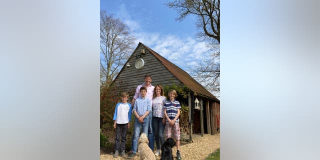 The Bubear family (left to right Ned, Olliem Charlie, Alice and Jake) watch as a WW1 grenade is removed from the gutter of their house. (Credit: SWNS)