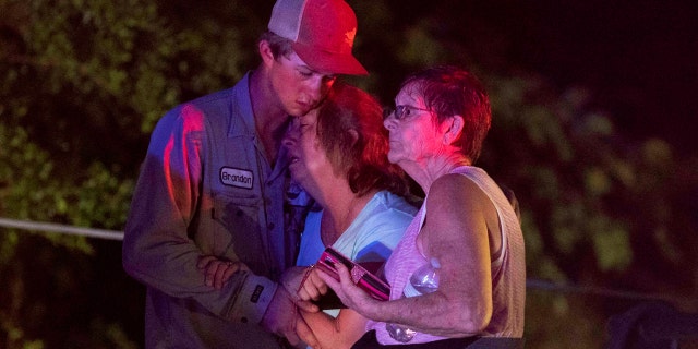 People embrace after an apparent tornado touched down Wednesday, April 22, 2020, in Onalaska, Texas.