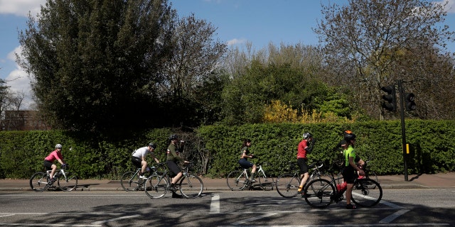 Cyclists spread out as they observe social distancing whilst waiting at a traffic light by Regent's Park, London, as London's parks remain open with the warning that they will close if people fail to observe the British government guidelines.