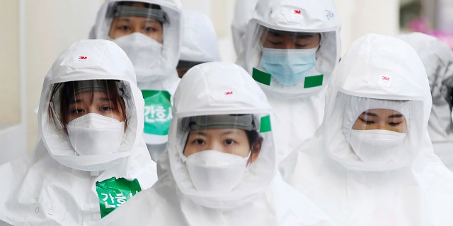 Medical staff members arrive for a duty shift at Dongsan Medical Center in Daegu, South Korea, March 30.