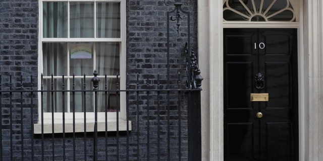 A drawing of a rainbow with the words "we are in this together" is displayed in one of the windows of 10 Downing Street in London, Thursday, April 9, 2020.