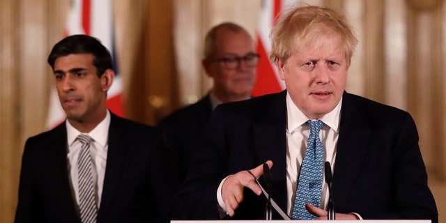FILE - In this file photo dated Tuesday, March 17, 2020, Britain's Chancellor Rishi Sunak, left, and Prime Minister Boris Johnson arrive for a press briefing about the ongoing situation with the COVID-19 coronavirus outbreak, inside 10 Downing Street in London.  (AP Photo/Matt Dunham, FILE)