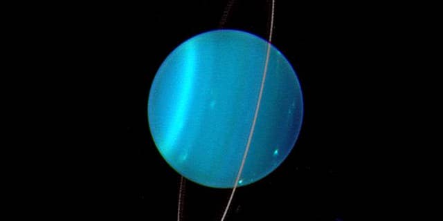 Uranus is uniquely tipped over among the planets in our Solar System. Uranus' moons and rings are also orientated this way, suggesting they formed during a cataclysmic impact which tipped it over early in its history. (Credit: Lawrence Sromovsky, University of Wisconsin-Madison/W.W. Keck Observatory/NASA)