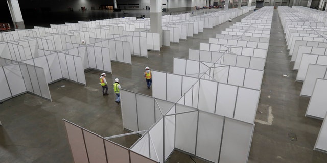 In this April 1 photo, the interior of the TCF Center with temporary hospital rooms is seen inside the convention center in Detroit. In the decade before Michigan and its largest city became the latest hotspot for the deadly coronavirus, officials were steadily cutting back on their first line of defense against pandemics and other health emergencies. Approaching bankruptcy, Detroit disbanded most of its public health department and handed its responsibilities to a private nonprofit. (AP Photo/Carlos Osorio)