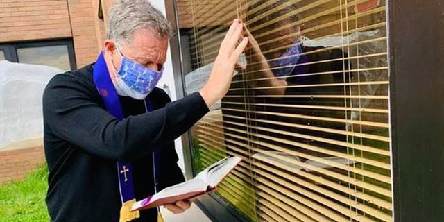Rev. Michael Way of Christ Episcopal Church in Middletown, New Jersey, recited the last rites through a window for a parishioner in the nursing home.