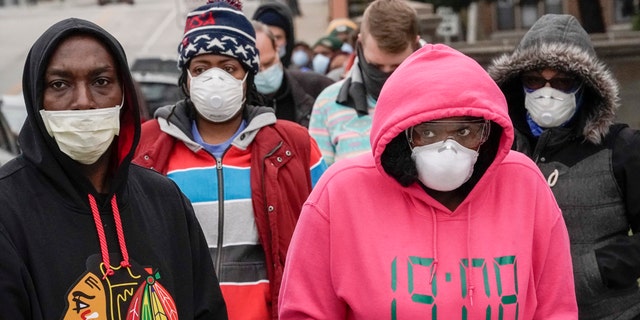 Voters masked against coronavirus line up at Riverside High School for Wisconsin's primary election Tuesday April 7, 2020, in Milwaukee. The new coronavirus causes mild or moderate symptoms for most people, but for some, especially older adults and people with existing health problems, it can cause more severe illness or death. (AP Photo/Morry Gash)