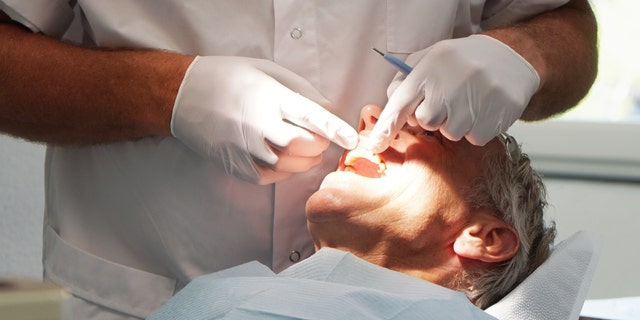Man at the dentist, having his teeth checked