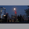 The Super Pink Moon rises behind the Empire State Building in New York City, lit to honor COVID-19 health care workers, on April 7, 2020.