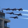 People watch as the U.S. Navy's Blue Angels fly past an apartment building as they perform a flyover tribute over New Jersey and New York City to honor COVID-19 front-line workers in Jersey City, New Jersey April 28, 2020. 