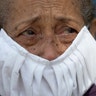 With tears on her eyes and wearing a homemade face mask, a devotee of the "Nazareno de San Pablo" watches a statue of Jesus transported in a Popemobile during Holy Week celebrations in Caracas, Venezuela, April 8, 2020. 