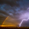 A bolt of lightning streaks near the vestiges of a rainbow as a thunderstorm rolls through Lewiston, Idaho, April 29, 2020. 