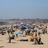 People are seen gathering on the beach north of Newport Beach Pier in Newport Beach, Calif., April 25, 2020. 