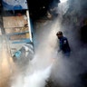 A worker fumigates a slum area to prevent dengue fever outbreak in Jakarta, Indonesia, April 22, 2020.
