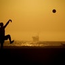 A couple plays volleyball on the sand in Huntington Beach, California, April 21, 2020.