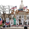 A Trump Unity sign on a trailer is shown parked at the protest in front of the Michigan State Capitol in Lansing.