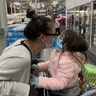 A Mother and young daughter share an intimate moment in a Costco in Los Angeles. Mother (36) - Aurora Lindsey Daughter (4) - Arielle Lindsey
