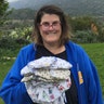 My name is Paige Johnson. I live in Ojai, California. I make cotton masks for local hospitals. This picture was taken in my backyard on March 28, 2020. I am holding 23 cotton masks that I made for a hospital in Ventura County, California