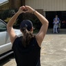 My daughter, Madison Panter, is shown keeping her distance from her grandparents after dropping off a care package of gloves, masks, disinfectant and food. She is giving then a symbol of love as they cry. This is in Powder Springs, Georgia.