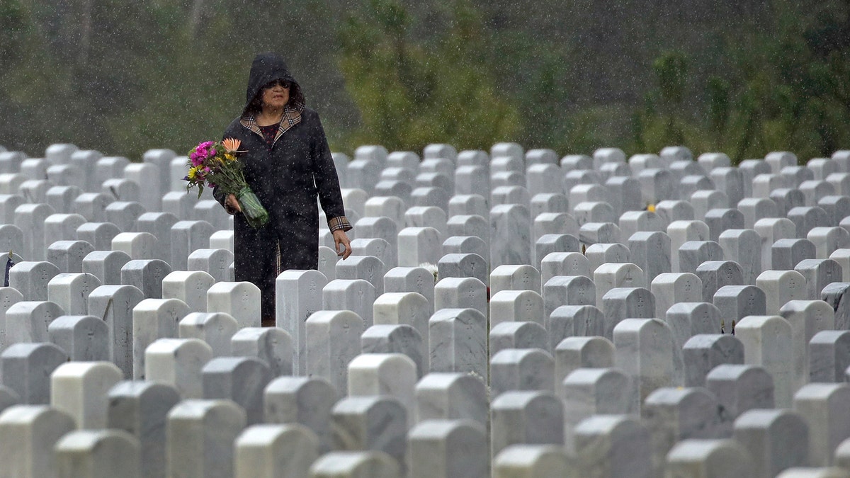 A woman looks for a grave on Memorial Day