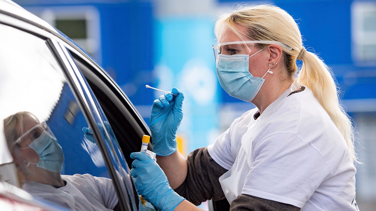 A person is tested for coronavirus at the drive through facility at the Edgbaston Cricket Ground Covid-19 testing site in Birmingham, England, Saturday May 2, 2020.