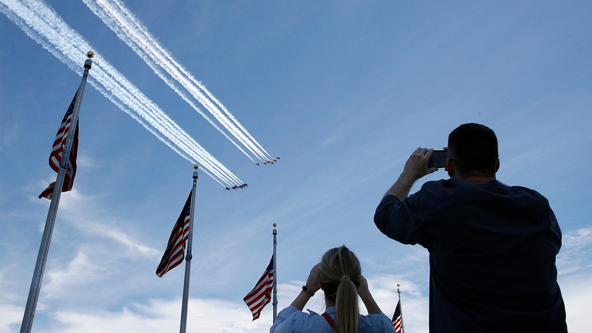 People view the U.S. Navy Blue Angels and U.S. Air Force Thunderbirds from the Washington Monument as they fly over the National Mall in Washington, Saturday, May 2, 2020. The flyover was in salute to first responders in the fight against the coronavirus pandemic. (AP Photo/Patrick Semansky)