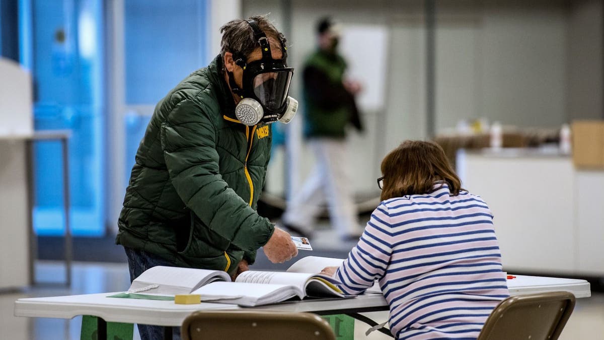 A voter wearing a full face chemical shield to protect against the spread of coronavirus, during Wisconsin's primary this past April. (Angela Major/The Janesville Gazette via AP, File)