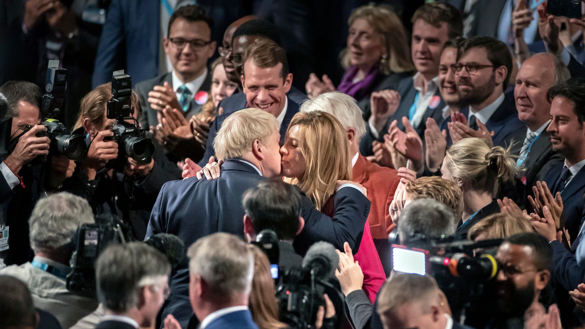 Britain's Prime Minister Boris Johnson, center left, kisses his partner Carrie Symonds at the Conservative Party Conference, in Manchester, England, Oct. 2, 2019. (Associated Press)
