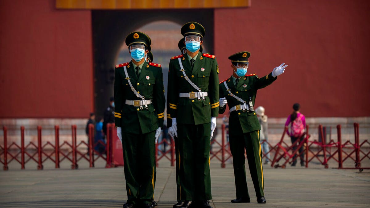 Chinese paramilitary police wear face masks to protect against the spread of the new coronavirus as they stand in formation outside an entrance to the Forbidden City in Beijing, Friday, May 1, 2020. The Forbidden City reopened beginning on Friday, China's May Day holiday, to limited visitors after being closed to the public for more than three months during the coronavirus outbreak. (AP Photo/Mark Schiefelbein)