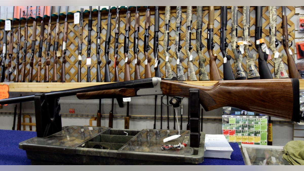 FILE - In a May 16, 2006 file photo, rifles line a hunting store's shelves in Ottawa. Prime Minister Justin Trudeau said Friday, May 1, 2020 that Canada is banning the use and trade of assault-style weapons immediately. (Jonathan Hayward/The Canadian Press via AP)
