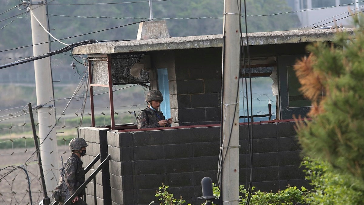 Army soldiers walk up the stairs of their military guard post in Paju, South Korea, near the border with North Korea on Sunday. North and South Korean troops exchanged fire along their tense border on Sunday, the South's military said, blaming North Korean soldiers for targeting a guard post. (AP Photo/Ahn Young-joon)