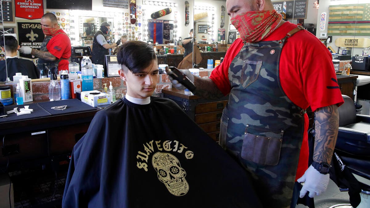 Juan Desmarais, right, the owner of Primo's Barbershop in Vacaville, Calif., on Monday.