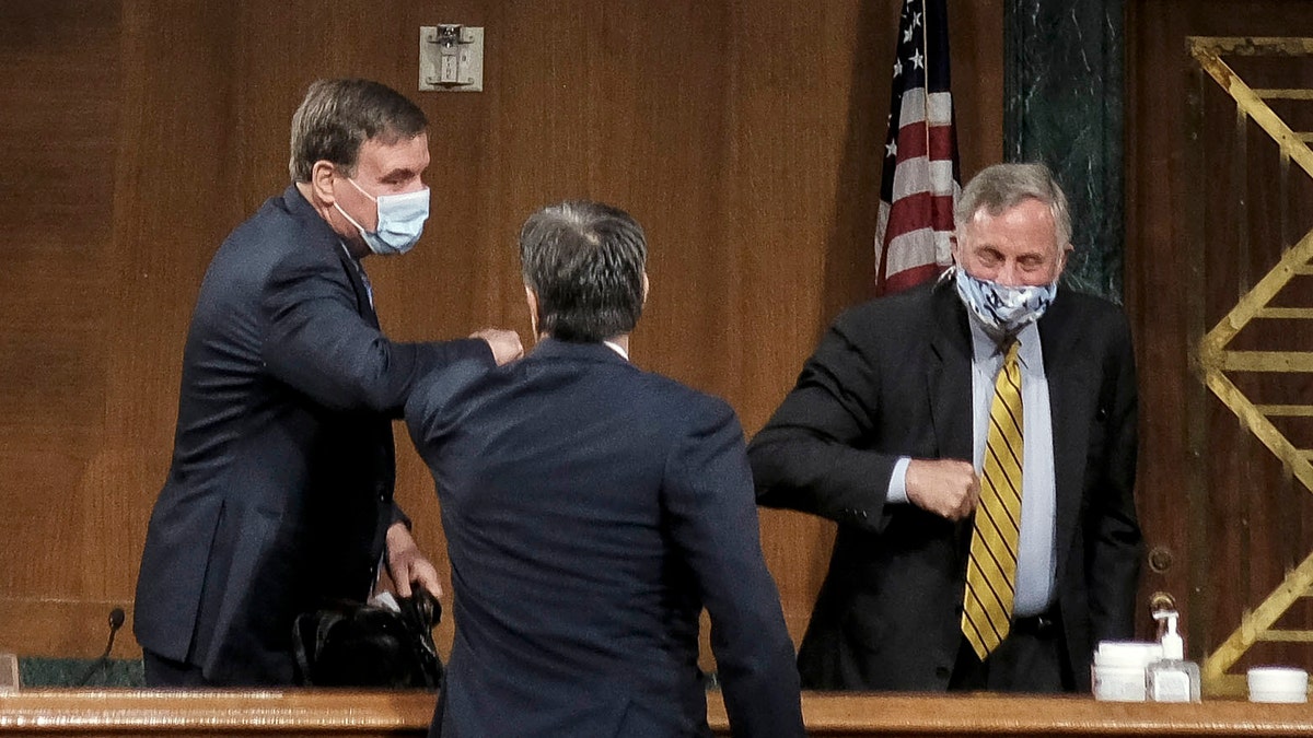 Senate Intelligence Committee Chairman Richard Burr, right, and Vice Chairman Mark Warner, left, greeting Rep. John Ratcliffe at his hearing Tuesday.