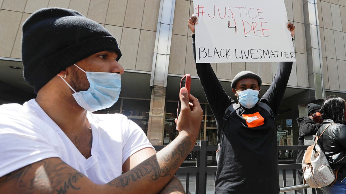 A protester holds a sign outside of the City County Building, Thursday, May 7, 2020, in Indianapolis. The crowd was protesting the fatal shooting Wednesday evening by an Indianapolis Metropolitan Police Officer. (AP Photo/Darron Cummings)