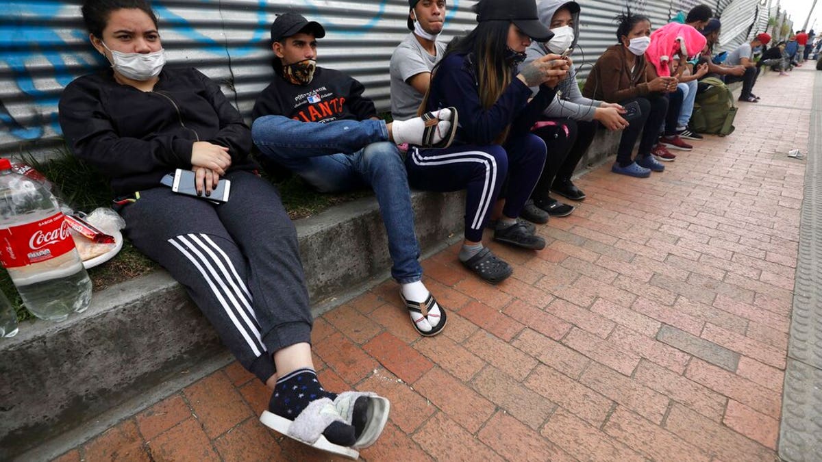 In this April 30, 2020 photo, Venezuelan migrants wait for buses that will transport them to the Venezuelan border, in Bogota, Colombia. 