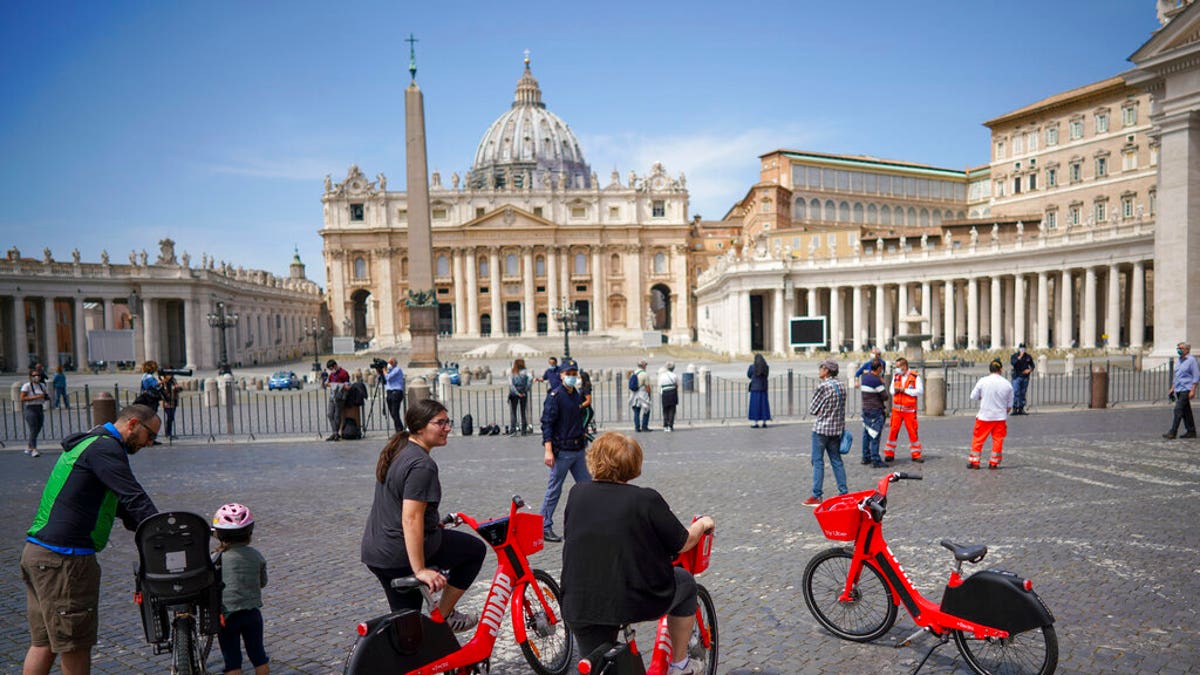 Faithful gather outside the square as Pope Francis delivers his blessing from the window of his studio overlooking St. Peter's Square, due to anti-coronavirus lockdown measures, at the Vatican, Sunday, May 10, 2020. 