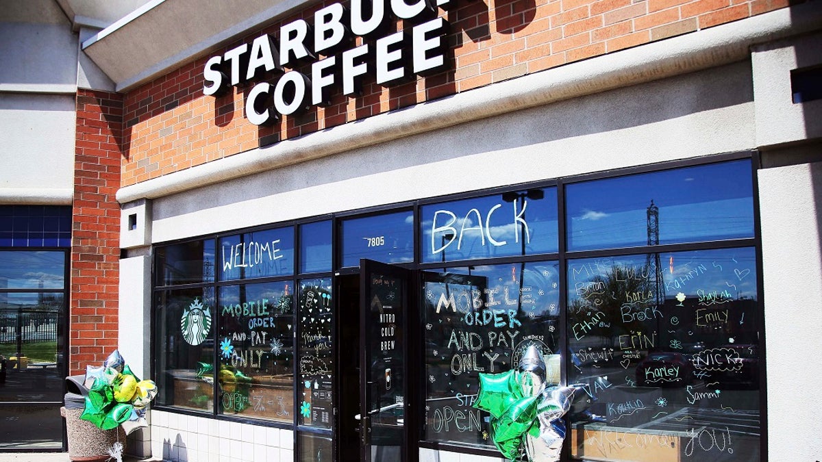 The Southtown Starbucks Coffee business, which was closed in March and reopened late last week, has a "WELCOME BACK" to customers on the windows Monday in Bloomington, Minn, where customers can pick up their online orders at curbside. (AP Photo/Jim Mone)