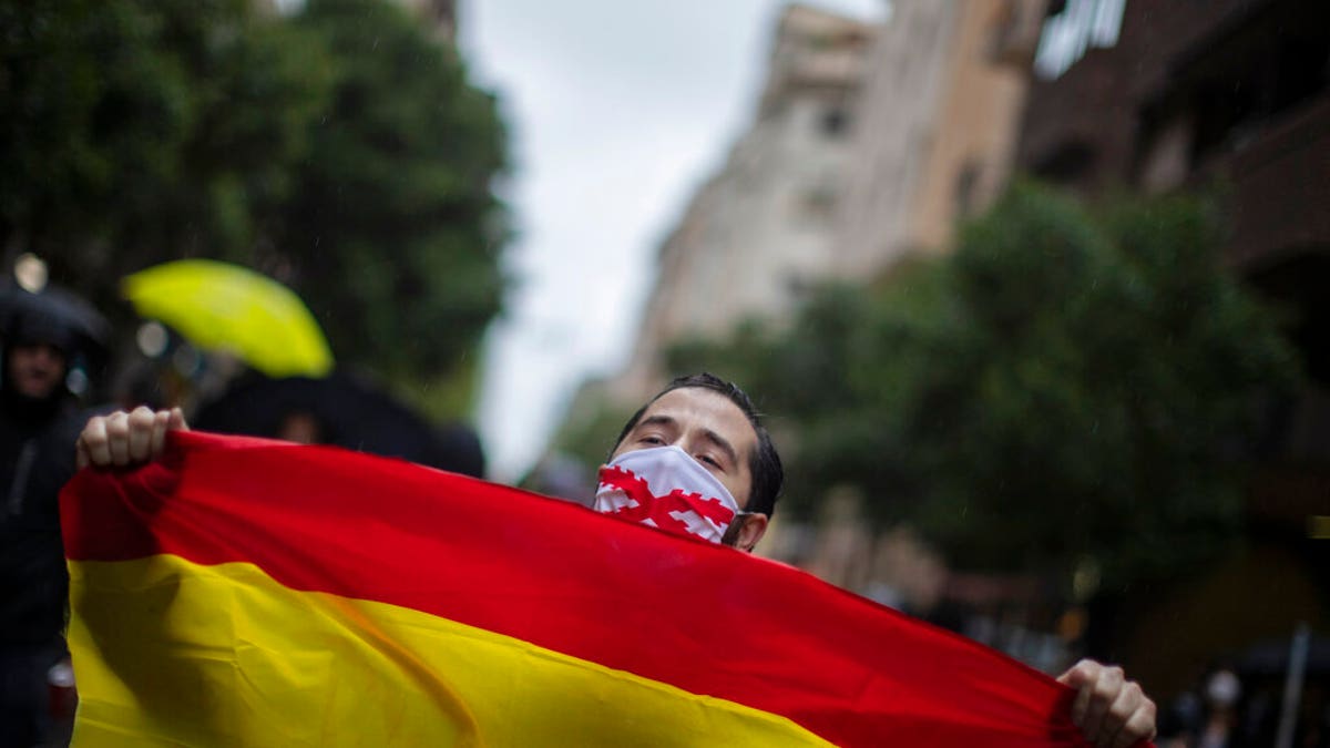 A man with a Spanish flag shouts slogans during a protest against the Spanish Government amid the lockdown to prevent the spread of coronavirus in Madrid, Spain, Tuesday, May 12, 2020.