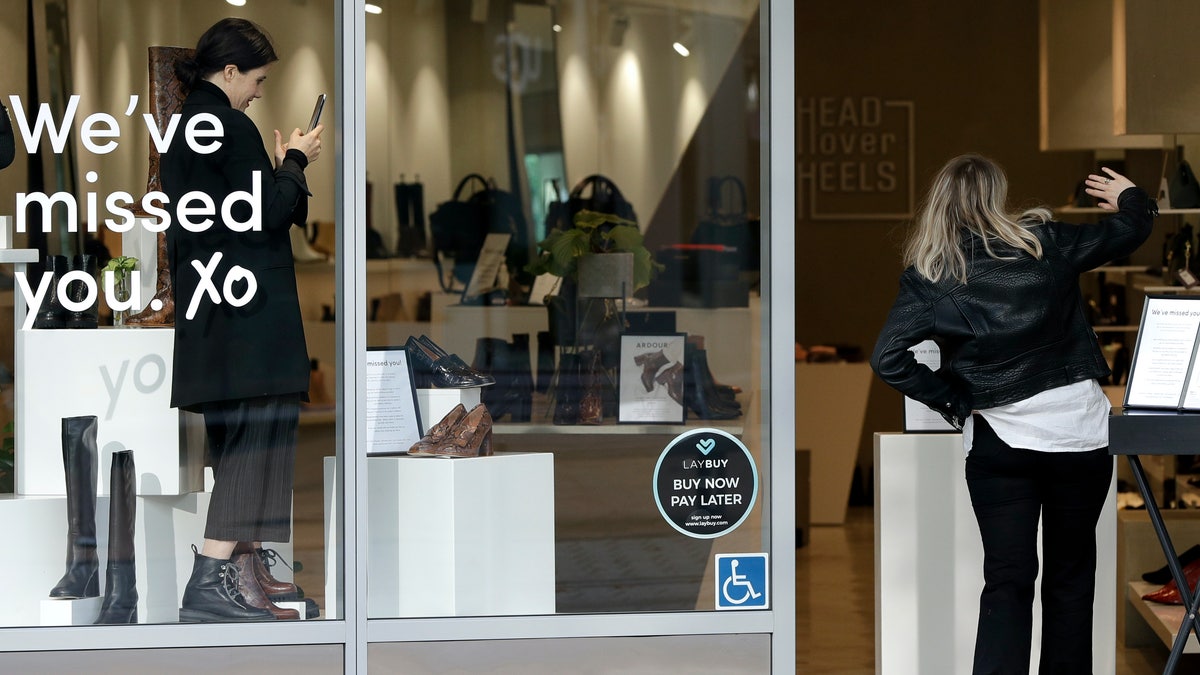 A customer gestures as she walks into a store in Christchurch, New Zealand, May 14. New Zealand lifted most of its remaining lockdown restrictions from midnight Wednesday as the country prepares for a new normal. Malls, retail stores and restaurants will reopen and many people will return to their workplaces. (AP Photo/Mark Baker)