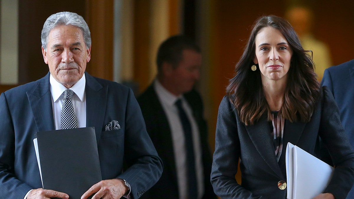 New Zealand Prime Minister Jacinda Ardern walks with Deputy Prime Minister Winston Peters to the house for the budget delivery speech at Parliament in Wellington, New Zealand, Thursday, May 14, 2020. New Zealandﾕs government plans to borrow and spend vast amounts of money as it tries to keep unemployment below 10 percent in the wake of the coronavirus pandemic. (Hagen Hopkins Pool Photo via AP)