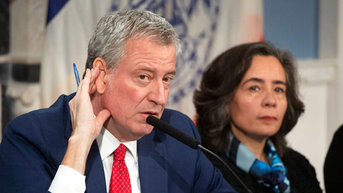 Feb. 26, 2020: Mayor Bill de Blasio, left, with Dr. Oxiris Barbot, commissioner of the New York City Department of Health and Mental Hygiene, listens to a reporter's question in New York. DeBlasio was one of the public officials that Gov. Andrew Cuomo Monday pressured to get hospitals under their responsibility to distribute vaccines faster. (AP Photo/Mark Lennihan)