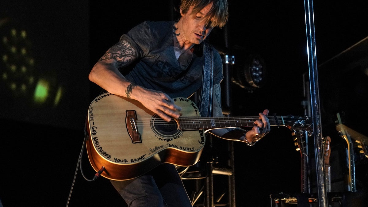 This image released by Guitar Monkey Entertainment shows Keith Urban, center, performing for first responders at the Stardust Drive In Theatre in Watertown, Tenn. on Thursday, May 14, 2020. The private show was set up exclusively for more than 200 doctors, nurses, emergency medical technicians and staff from Vanderbilt Health, part of Vanderbilt University Medical Center. 