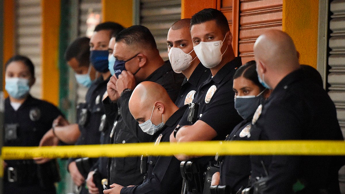 Los Angeles Police Department officers stand at the scene of a structure fire that injured multiple firefighters, according to a fire department spokesman, Saturday, May 16, 2020, in Los Angeles. (Associated Press)