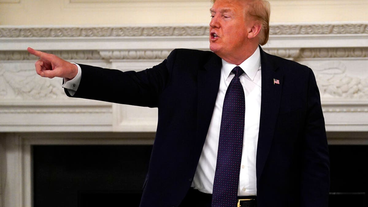 President Donald Trump gestures as he leaves after a meeting with restaurant industry executives about the coronavirus response, in the State Dining Room of the White House, Monday, May 18, 2020, in Washington. (AP Photo/Evan Vucci)