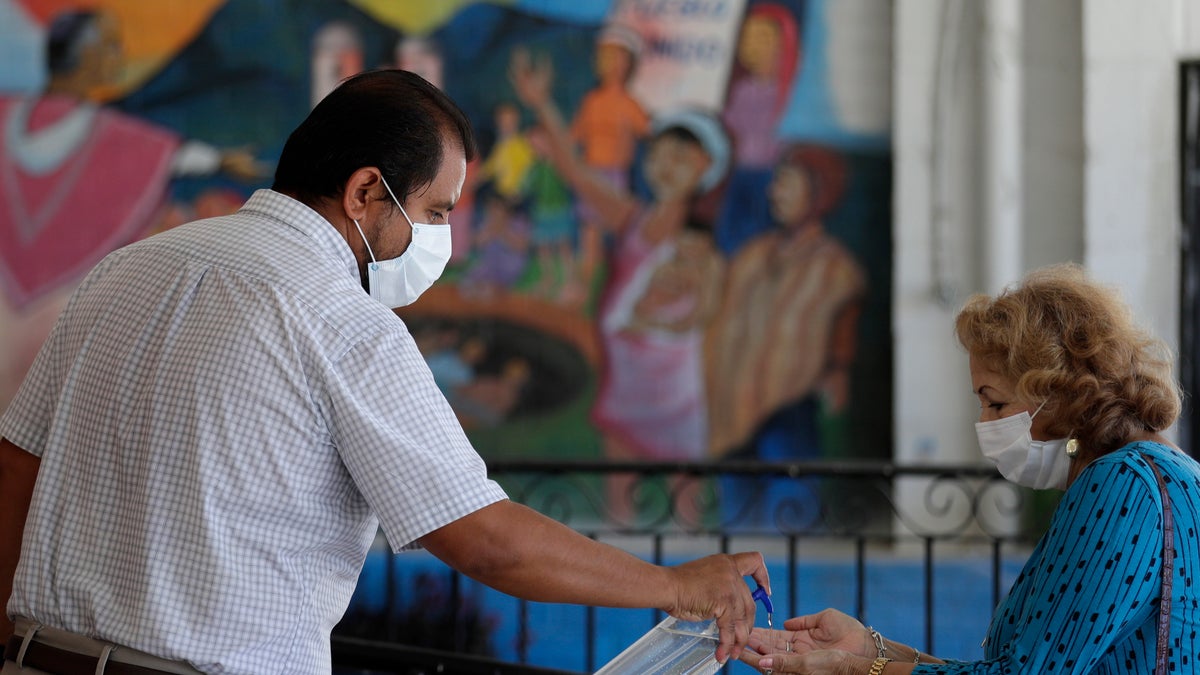 Parishioners wearing face masks are given hand sanitizer as they arrive for an in-person Mass using social distancing at Christ the King Catholic Church in San Antonio, May 19. San Antonio parishes that have been closed due to the COVID-19 pandemic have began opening their doors to in-person services. (AP Photo/Eric Gay)