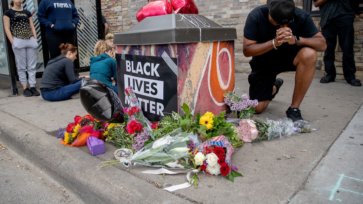 People gather and pray around a makeshift memorial, May 26, in Minneapolis, near the site where a black man, who was taken into police custody the day before, later died. Elizabeth Flores/Star Tribune via AP