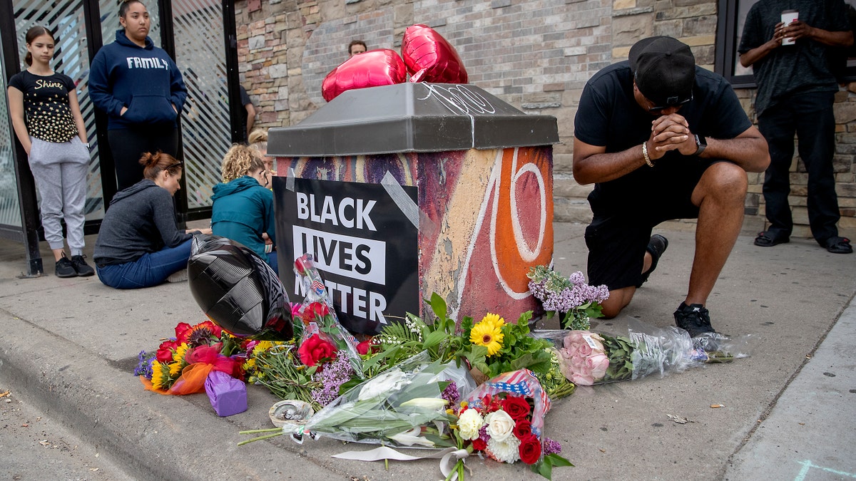 People gather and pray around a makeshift memorial, May 26, in Minneapolis, near the site where a black man, who was taken into police custody the day before, later died. Elizabeth Flores/Star Tribune via AP