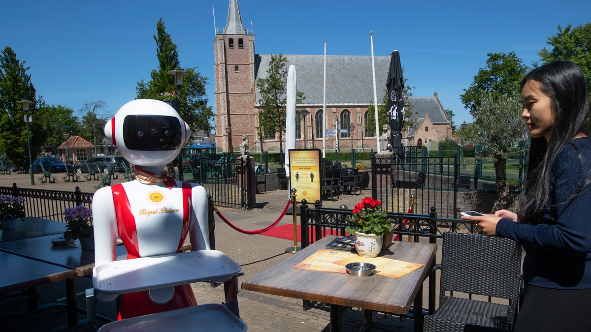 The robotic servers may help to ease customer’s minds and get business booming again when restaurants finally open their doors next week, as lockdown restrictions are further eased in the Netherlands. (AP Photo/Peter Dejong)