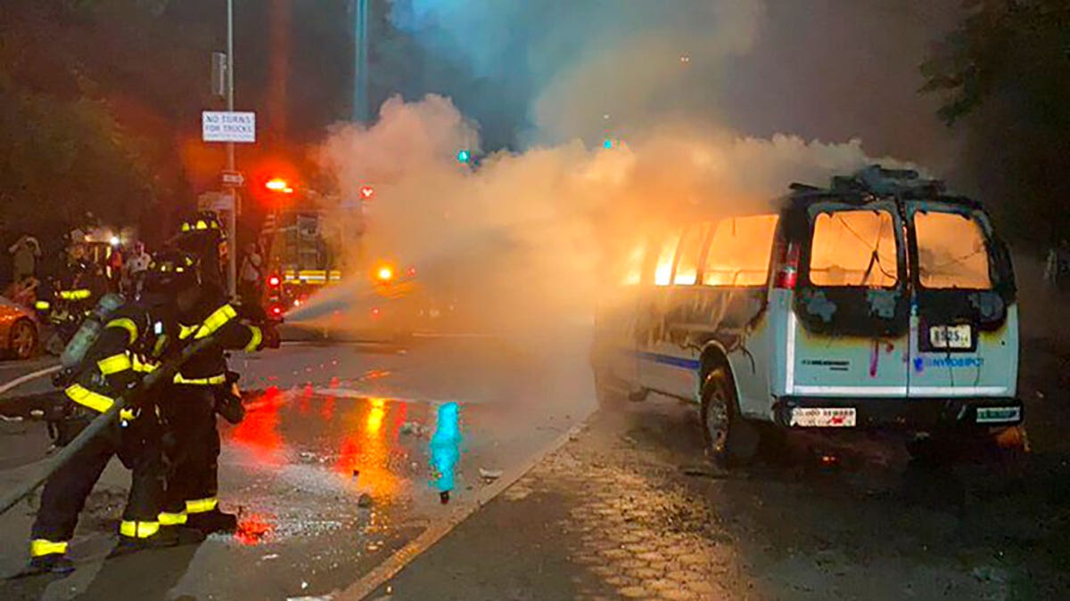 In this photo provided by Khadijah, firefighters work to contain the flames from a New York City Police Department van ablaze, Friday, May 29, 2020, in the Brooklyn borough of New York, amid a protest of the death of George Floyd in police custody on Memorial Day in Minneapolis.