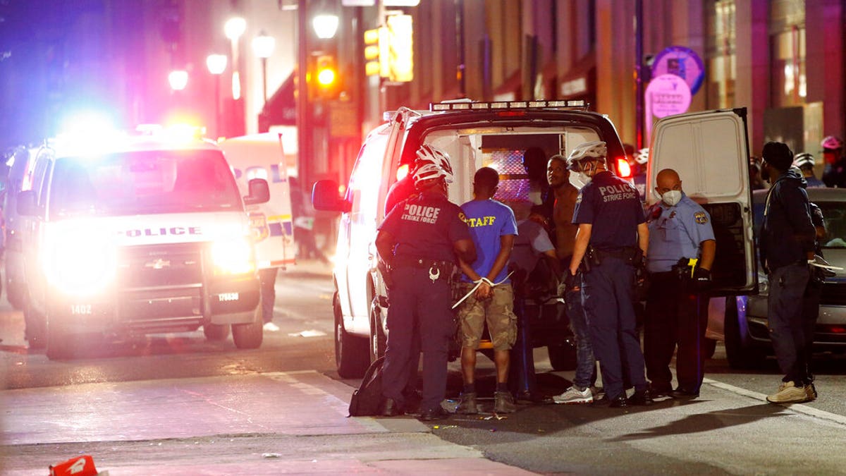 Philadelphia police officers detaining people Saturday as protests devolved into riots.